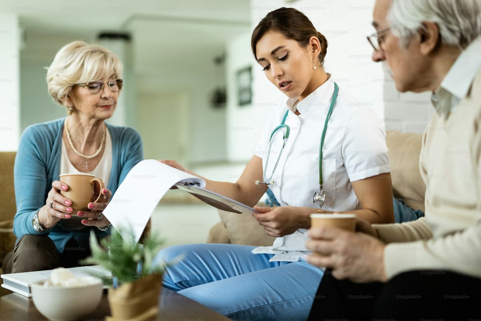 A healthcare worker discussing medical test results with a senior couple at home