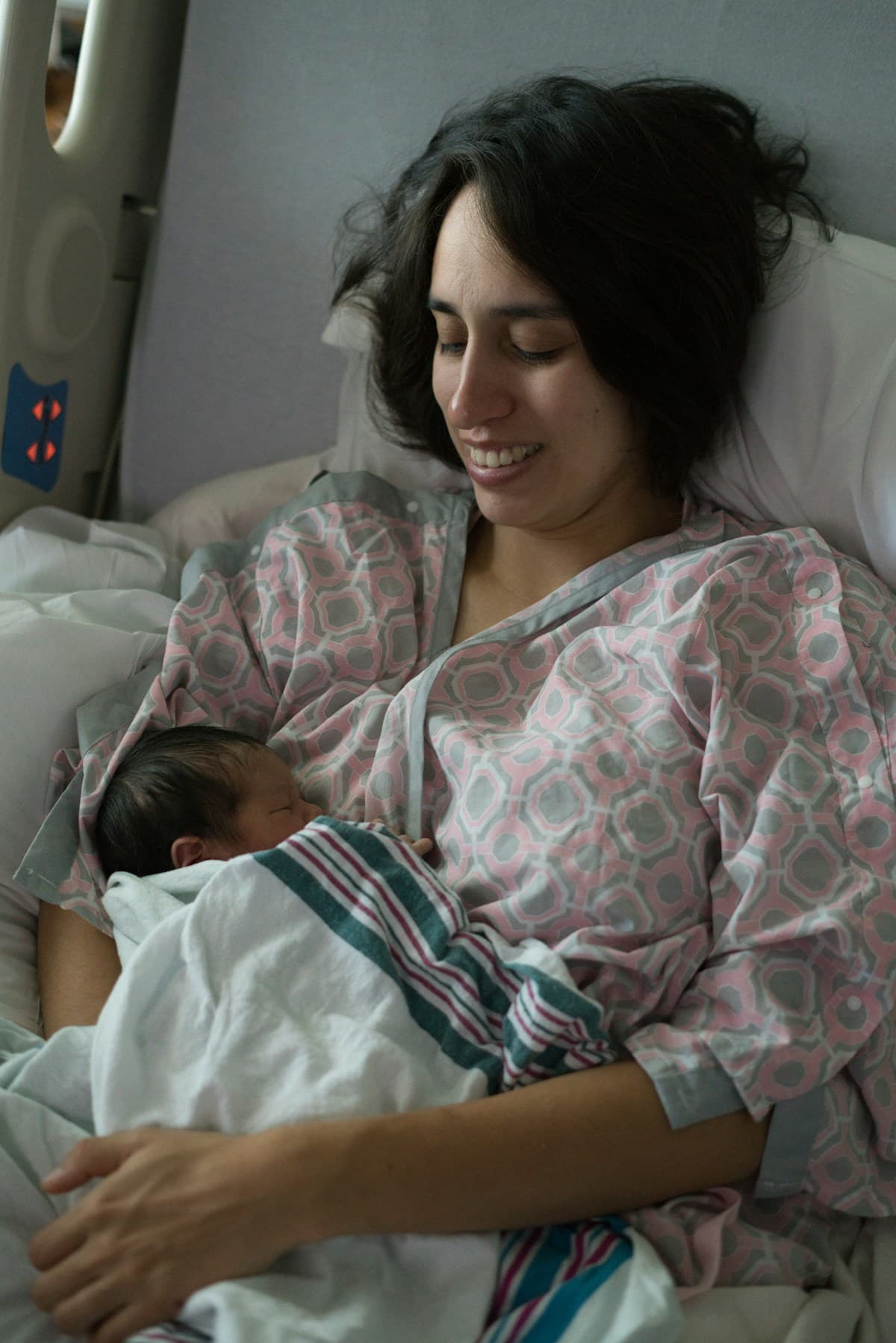 A mother resting with her newborn baby in a hospital bed